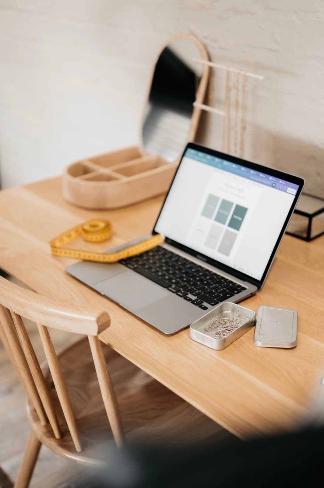 A laptop on a wooden desk displaying a digital colour palette