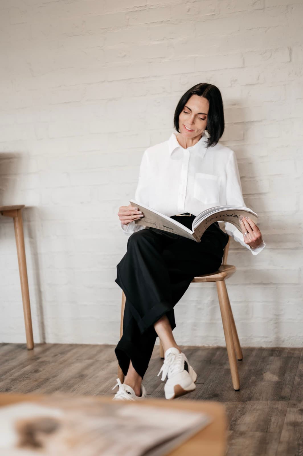 Belinda paging through a style workbook in her ivory studio